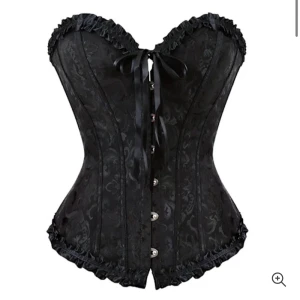 Svart korsett med rosett och spets - Säljer den populära efterfrågade korsetten! Säljer då den var lite för liten, helt oanvänd, bara testad! Perfekt nu till halloween! 