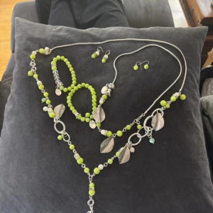 Set med gröna pärlsmycken och lövdetaljer - Unika smycken från Design Bissebeth! Hon gör inte smycken längre tyvärr!Jag förbehåller mig rätten att eventuellt ha missat ng skönhets defekt! Därav priset, vill hellre att de används än att de ligger i lådan!Silverfärgen på örhängena samt några andra pärlor har mörknat (ärgat)! Smyckena ligger bara tyvärr, trots min favoritfärg! ett matchande smyckeset med halsband, armband och två par örhängen. 