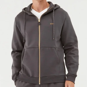 Mörkgrå hoodie från BOSS med gulddragkedja - Har slutat passa min son då den är i storlek M. Inte använt så mycket så är i ganska nytt skick(Inköpspris: 1999kr) 