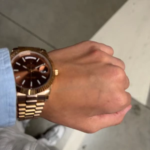 Guldbrun klocka - Säljer en snygg R Day-Date med brunt urtavla och klassisk länk i guldton. Klockan har tydliga index, datum- och veckovisning samt räfflad bezel. Den robusta länken och den eleganta färgkombon gör den till ett riktigt statement-piece. Kontakta mig gärna via pm för mer bilder samt information 👍//Cleanseller