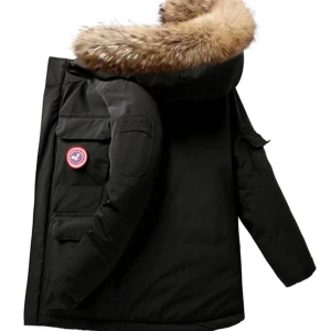 Canada Goose dunjacka med pälskrage - Säljer en Canada Goose dunjacka med stor huva och pälskant. Jackan finns i både svart och beige, har flera stora fickor och klassisk logga på bröstet. Perfekt för kalla vinterdagar med sin tjocka fyllning och snygga design.