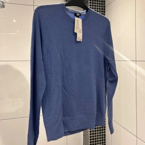 Blå tröja i merinoull från Uniqlo - Säljer en stilren blå tröja från Uniqlo i extra fin merinoull. Den är maskintvättbar vilket gör den både praktisk och bekväm. Tröjan är helt oanvänd då den inte har kommit till användning! Om du har fler frågor eller funderingar så ska du inte tveka på att kontakta!  OBS ! Lapparna i bilden sitter ej kvar men fortfarande i samma bra skick!