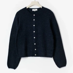 Mörkblå stickadkofta från Gina tricot - Mysig mörkblå kofta från Gina Tricot i fluffig stickad ullblandning. Rund halsringning, långa ärmar och vita knappar framtill. Tröjan är i storlek s och är nästan inte använd. Ordinariepris 400.❣️