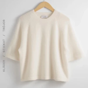 Vit stickad tröja från & Other Stories - Supermjuk och fluffig vit stickad tröja från & Other Stories. Tröjan har en rund halsringning och korta ärmar, vilket ger en chill och avslappnad vibe. Perfekt att styla med jeans eller kjol för en enkel men snygg look.
