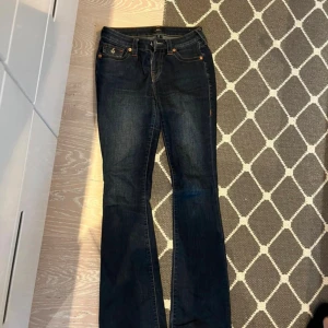 True Religion Bootcut Jeans Midwaist - !PRIS KAN DISKUTERAS VID SMIDIG AFFÄR!Dom absoluta skönaste jeansen nånsin!! ❤️ Mörkblåa, mid waist och bootcut. Haft ett tag men asbra skick!! Ser nya ut. 🥰 storlek 26. Skulle säga att de motsvarar 34/36!