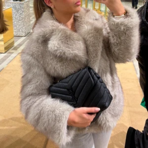 Beige pälsjacka från Zara - Snygg och fluffig beige pälsjacka från Zara med bred krage och lång ärm. Jackan har en klassisk, lite boxig passform och är tillverkad i mjukt fuskpälsmaterial som ger en lyxig känsla. Perfekt för dig som vill sticka ut med en trendig look.