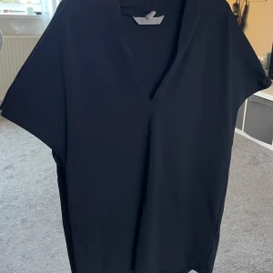 Svart kortklänning med v-ringning - Säljer denna svart blus med v ringning då den inte kommer till användning. Storlek xs från H&M. Använd några gånger💞