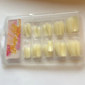 Design Nail konstgjorda naglar - Säljer ett set med 100 konstgjorda naglar från Design Nail i en praktisk plastförpackning. Naglarna är ljusgula och har en klassisk, lätt böjd form som passar för både förlängning och dekoration. Perfekt för dig som vill fixa snygga naglar hemma.
