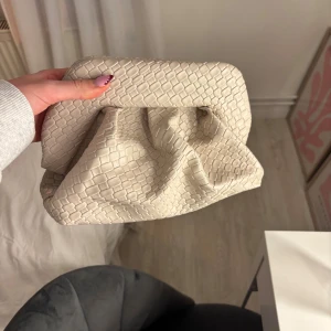 Helt oanvänd Clutch väska - Snygg beige clutchväska med coolt ormmönstrat yttre i skinnimitation. Väskan har en mjuk, puffig form och magnetstängning. Insidan är fodrad med ljus satin. Rymlig och aldrig använd!❤️‍🔥
