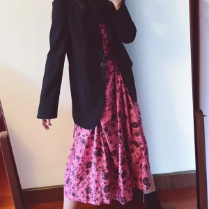 Rosa blommig omlottklänning från Ganni - Supersnygg rosa omlottklänning från Ganni med mörkbrunt blommigt mönster. Klänningen har v-ringning, knyt i midjan och trekvartsärmar. Den är lång och har en luftig passform som ger en cool och avslappnad vibe. Perfekt för dig som vill sticka ut med färg och mönster. Size 3, equivalent to size 38. 