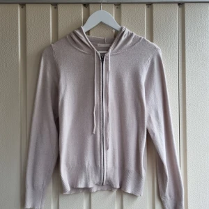 Hoodie med dragkedja  - Snygg beige hoodie från 157 med dragkedja och huva. Enkel och vardaglig tröja i mjukt material. Köpt från second hand och använd en enstaka gång.