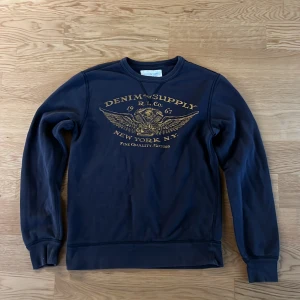 Mörkblå sweatshirt från Ralph Lauren - Säljer en mörkblå sweatshirt från Denim & Supply Ralph Lauren med en fet vintage design på bröstet. Inga defekter