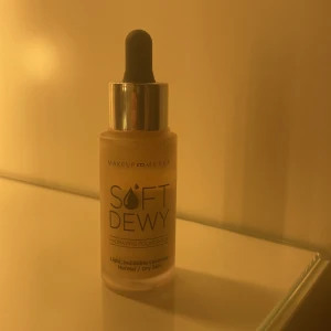 Soft Dewy Foundation White Mocha - Hydrerande foundation från Makeup Mekka i nyansen White Mocha. Kommer i en frostad glasflaska med pipett för enkel applicering. Ger lätt, byggbar täckning och passar normal till torr hud. Perfekt för en fräsch och daggig finish.