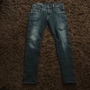 Replay Anbass jeans blå w29 L32 - Säljer ett par Replay Anbass jeans i blå tvätt med snygg tvätt. Modellen är slim fit med klassiska fem fickor och dragkedjegylf. Jeansen har Replay-logga på fickan och är tillverkade i stretchig denim för en bekväm passform. 