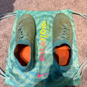 Nike phantom GX Luna fotbollsskor - Ett par grymma fotbollsskor från Nike! De är lite smutsiga, vilket gör för att priset är väldigt bra för ett så pass bra par dojor. Som sagt, lite smutsiga. Men de har fortfarande ett par säsonger kvar i sig! Hör gärna av er vid frågor. Storlek 43.