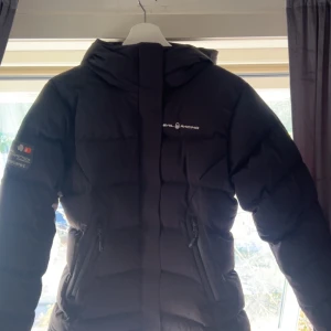 Svart pufferjacka från Sail Racing - Säljer en svart pufferjacka från Sail Racing den är i storlek medium men sitter mer som small jackan är som ny använd 1 gång 