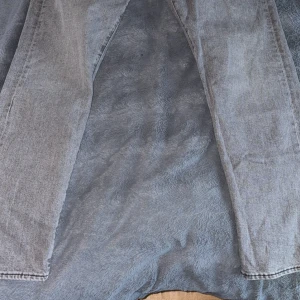 Grå Levis 511 jeans straight fit - Snygga grå Levis 511 jeans med klassisk femficksdesign och raka ben. Jeansen har en diskret tvättad look, Levis-lapp bak i midjan och röd etikett på bakfickan. Perfekta för dig som gillar en stilren och avslappnad vibe.