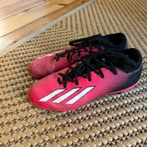 Adidas fotbollsskor med snörning - Säljer ett par snygga rosa/svarta fotbollsskor från Adidas. Skorna är slitna, men håller ett tag till för den som är ok med lite märken och litet hål vid enda tån. Storlek 36 eller ca 22 cm innermått.