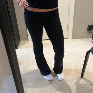 Svarta bootcut yogapants med låg midja - Säljer ett par svarta bootcut byxor med låg midja och stretchigt material. Snygg passform som sitter tajt över låren och släpper vid vaden. Perfekta för dig som gillar en trendig och bekväm look.