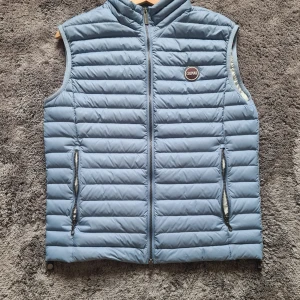 Colmar dunväst - Snygg blå dunväst från Colmar med quiltad design och hög krage. Den är i mycket bra skick med endast en liten knappt synbar färgdefekt, se bild 4. Den är I storlek 48/M. Perfekt inför hösten/vintern🔥 hör av dig vid frågor!