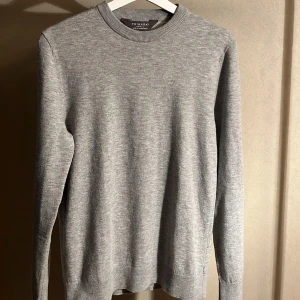 Grå stickad tröja från Primark - En stilren grå stickad tröja från Primark med rund halsringning och långa ärmar. Perfekt för lager-på-lager och enkel att matcha med jeans eller chinos. Mjuk och bekväm, passar dig som gillar en clean och klassisk look.