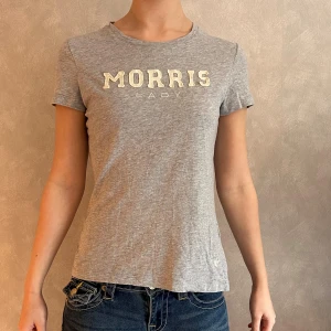 T-Shirt MORRIS - En grå T-Shirt från MORRIS Lady. Storlek XS. Fint skick, utom att texten är något missfärgad (se bild 2)! Skriv vid frågor/ funderingar/ mått!🥰 PRISET ÄR ALLTID DISKUTERBART!😍