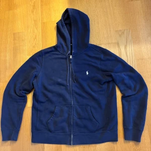 Mörkblå Ralph Lauren hoodie  - Mörkblå Ralph Lauren hoodie  Skick 7/10 OBS! Storlek XL men sitter som M varav barnstorlek! Hör av er vid fler frågor eller funderingar.