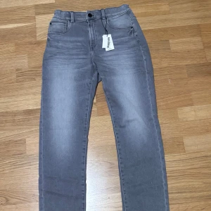 Grå relaxed jeans från Kappahl 170cl - Snygga grå relaxed jeans från Kappahl i modellen Jogger denim. Byxorna har stretch, resår i midjan och klassisk femficksdesign. Perfekt för dig som gillar en loose och bekväm passform med raka ben och stilren look. (Har aldrig använt dom, helt nya)
