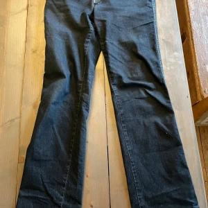 Mörkblå jeans från Armani Jeans - Snygga mörkblå jeans från Armani Jeans med klassisk rak passform och tydliga kontrastsömmar. Byxorna har ett ikoniskt Armani-märke i metall på bakfickan och är tillverkade i slitstarkt denimtyg. Perfekta för dig som gillar stilrena och tidlösa jeans. De är även lite bootcut men skulle säga mest raka