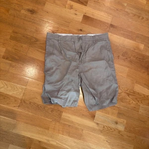 Beige shorts från H&M Relaxed Fit - Snygga beige shorts från H&M i relaxed fit med klassisk design. De har bälteshällor, två sidofickor och två bakfickor med knappar. Perfekta för varma dagar och enkla att matcha med det mesta. Materialet är lätt och känns skönt mot huden.