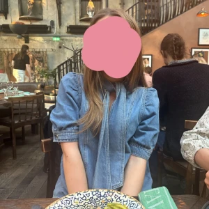 Jeans blus med knyt från Zara - Ljusblå jeansblus från Zara med korta puffärmar och rosett vid halsen. Storlek S. Perfekt till fest!