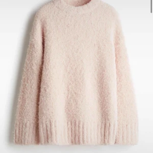 Ljusrosa fluffig stickad tröja - Supermjuk och fluffig ljusrosa stickad tröja med rund hals och långa ärmar. Perfekt för kalla dagar när du vill vara både varm och snygg. Ribbstickade muddar vid ärmslut och nederkant ger en extra mysig känsla.