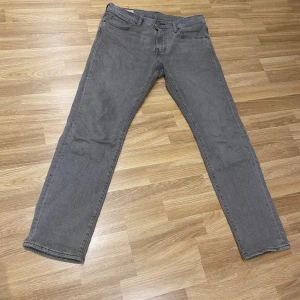 Grå Levi's 502 jeans W30 L32 - Snygga grå Levi's 502 jeans med klassisk femficksdesign och raka ben. Jeansen har en stilren look med läderpatch bak i midjan och är tillverkade i mjukt denimtyg. Perfekta för dig som gillar en enkel och clean stil.