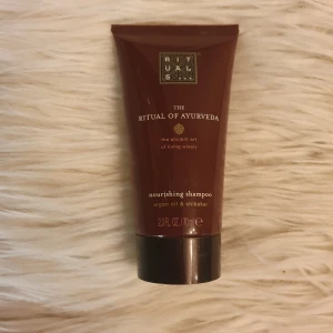 Rituals The Ritual of Ayurveda shampoo - Nourishing shampoo från Rituals The Ritual of Ayurveda med arganolja och shikakai, oanvänd. Kommer i en mörkröd tub på 70 ml med gulddetaljer.