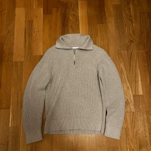 Beige halfzip - Superfin och stilren tröja med dragkedja vid halsen. Passarbra till jeans för en avslappnat men välklädd look. Mjuk, varm och skön kvalitet som håller formen. Använd ett fåtal gånger i riktigt fint skick! Köpt för 800kr