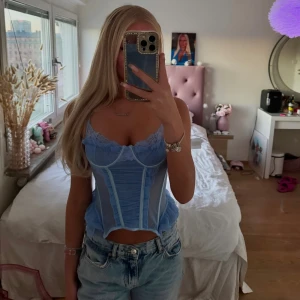 Blå korsettop - Jättefin ljusblå korsettop med volang och spets detaljer 💕 Helt ny och oanvänd, med lapp kvar! Från EGO, nypris 300kr, säljer för 200kr. - Storlek UK 6, passar XS Skriv privat för fler bilder eller frågor 🫶🏽 