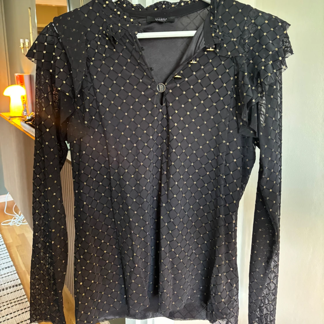 Svart blus med guldprickar