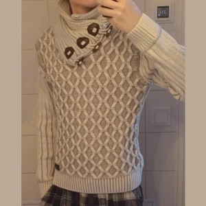 Leif Nelson chunky knit polo / funnel neck tröja - Superfin ljusgrå stickad tröja från Leif Nelson i storlek S. Tjock, mjuk och varm kvalitet med ett unikt diamant mönster framtill och ribbad baksida. Stor krage med dekorativa knappar, går att ha uppvikt eller nedfällt. Sitter snyggt och kroppsnära. Inga hål eller fläckar. Perfekt för vintern och ser lyxig ut. För reference är jag 180 / 63. 