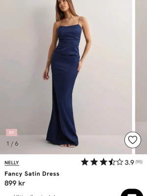 Marinblå långklänning i satin från Nelly - Supersnygg marinblå långklänning i satin med smala axelband och öppen rygg. Har endast testat den och den har prislappen kvar!
