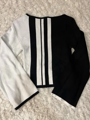 Svartvit stickad tröja med ränder - Säljer en svartvit stickad tröja med lång ärm. Som också är bredare längst med armarna. Passformen på tröjan är rak. Storlek xs, ifrån Gina tricot. Mycket bra skick, använd en gång.