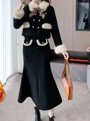 Set Svart jacka  med fuskpäls och kjol - Säljer ett svart tvådelat set med kavaj och lång kjol. Kavajen har vit fuskpäls på krage, ärmslut och fickor, guldknappar och en beige rosett vid halsen. Kjolen har matchande fuskpälsdetaljer på fickorna. Setet har en elegant och chic look.