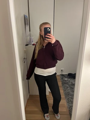 Svarta kostymbyxor med bootcut - Säljer ett par svarta kostymbyxor med bootcut-snitt. Byxorna har en klassisk look med normal passform och är perfekta för dig som gillar stilrena och enkla plagg. Materialet känns mjukt och följsamt, och de har en snygg midwaist-modell.