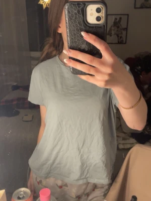 Ljusgrå basic t-shirt från 157 - En enkel och clean ljusgrå t-shirt från 157 i 100% bomull. Modellen är rak med korta ärmar och rund halsringning. Perfekt till jeans eller shorts för en chill look.