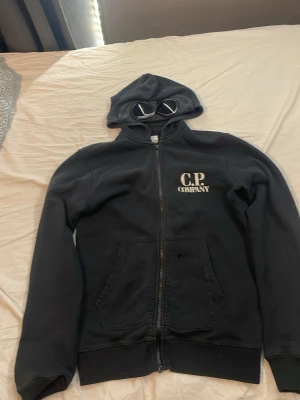 Cp company hoodie  - En svart cp company hoodie, ett litet hål som man ser på sista bilden som lätt går att laga, priset går att diskutera, hör av er vid funderingar 
