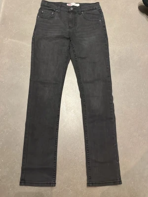 Svarta Levi’s jeans  - Säljer ett par svarta Levi's 512 slim taper jeans med klassisk femficksdesign och raka ben. Storleken på jeansen är 14a. Jeansen har en diskret tvättad look, normal passform och är tillverkade i mjukt jeansmaterial. Jeansen är änvånda 1-2 gånger, så är väldigt bra skick. Hör av er vid minsta fundering eller intresse om jeansen. 😊