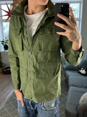 Olivgrön Fieldjacket - Trendig och stilren, mycket bra skick. Mått: A:46 B:47 C:46 D:63 (cm) skriv vid fundering!🙌