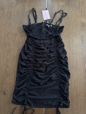 Svart kortklänning Missguided - Svart kortklänning från Missguided med justerbara axelband. Klänningen har en figurnära passform. Storlek 36, aldrig använd. 