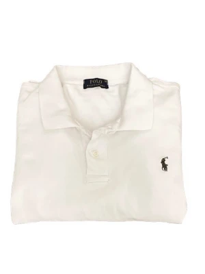 Vit pikétröja från Ralph Lauren M - Klassisk vit pikétröja från Ralph Lauren med korta ärmar och krage. Tröjan har den ikoniska broderade loggan på bröstet och stängs med två knappar framtill. Tillverkad i mjuk bomull som känns skön mot huden.