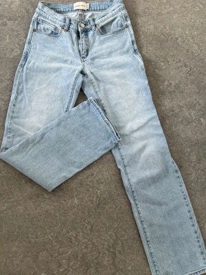 Ljusblå raka jeans från Abrand - Ljusblå jeans från Abrand med klassisk femficksmodell och raka ben. Svart patch på bakfickan ger en clean detalj. Storlek 24 modell A’99 low straight 