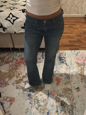 Levis 517 blå bootcut jeans - Ett par klassiska blå Levis jeans med bootcut passform. Jeansen har fem fickor, normal midja och den ikoniska Levis-lappen bak. Tillverkade i slitstarkt denim med raka ben som får en snygg siluett.